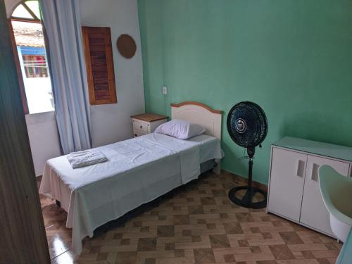 a bedroom with a bed and a fan in it at Belvedere das Estrelas in Lençóis