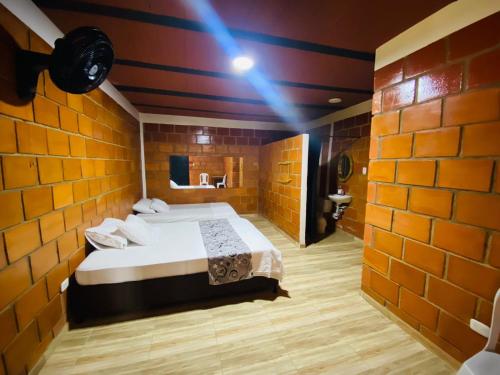 a bedroom with a bed in a brick wall at Finca Hotel Villa Nieves in Tuluá
