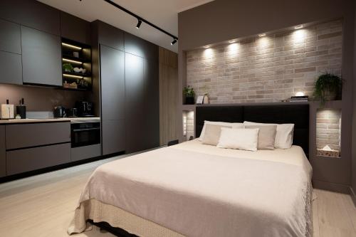 a bedroom with a large bed and a brick wall at SkyGarden Studio - Private Terrace and View in Quiet Jūrmala in Jūrmala