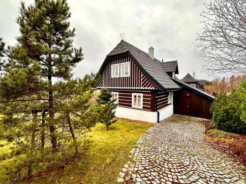 a house with a black and white roof at Chalupa U Pastýře in Vysoké nad Jizerou