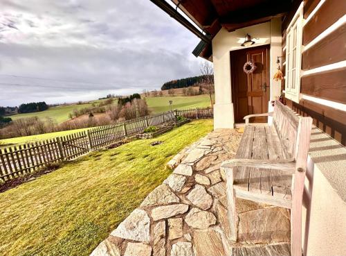 a wooden bench sitting on the porch of a house at Chalupa U Pastýře in Vysoké nad Jizerou