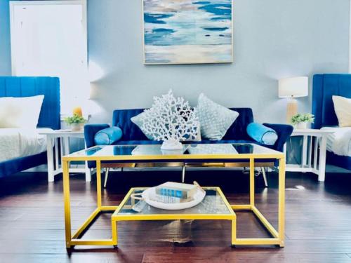 a living room with a blue couch and a yellow coffee table at Surf & Strand Unit B in Galveston