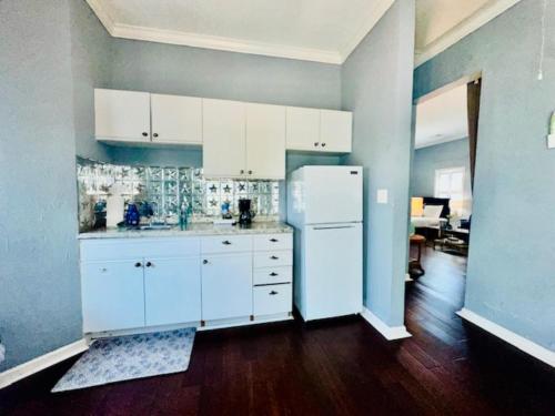 a kitchen with white cabinets and a white refrigerator at Surf & Strand Unit B in Galveston