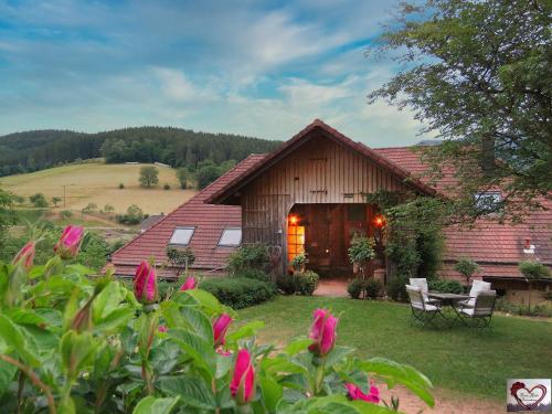 ein Haus mit rosa Blumen davor in der Unterkunft Hernis-Höfle 5 Sterne "Wohlfühlambiente " im Elztal in Elzach