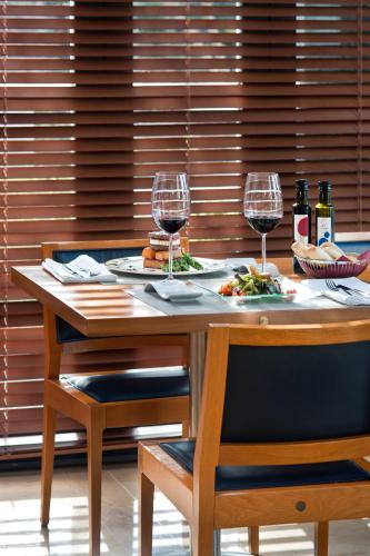 a wooden table with two glasses of wine at Ibis Lleida in Lleida