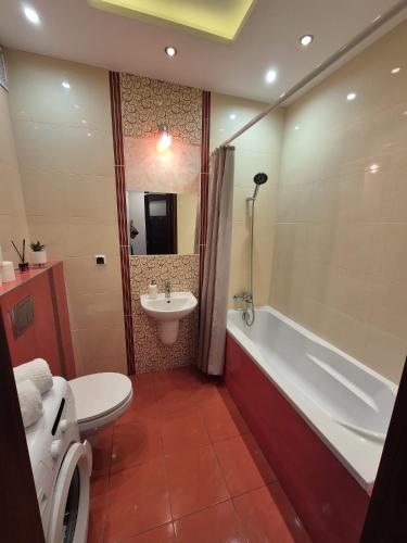 a bathroom with a tub and a toilet and a sink at Serce Suwałk in Suwałki