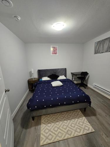 a bedroom with a bed with a blue comforter at Omos Home in Saskatoon