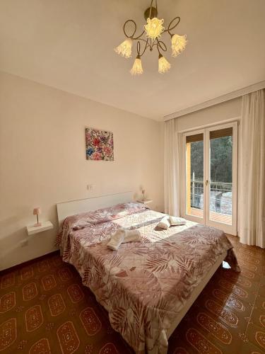 a bedroom with a large bed and a chandelier at Casa Fiocco vista Lago in Pisogne