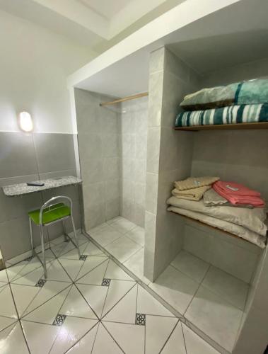 a room with a shower with a chair and a table at Microcasas in Nova Friburgo