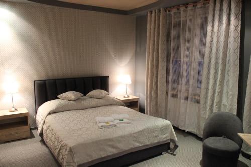 a bedroom with a bed and two lamps and a chair at Sosnowe Zacisze in Białystok
