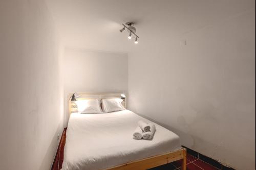 a small bedroom with a bed with two slippers on it at Alfama Tiny by Homing in Lisbon