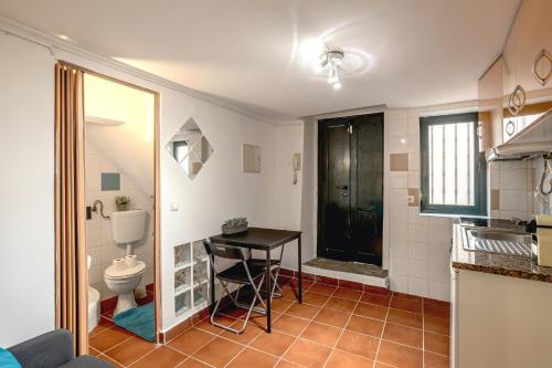 a bathroom with a toilet and a table in it at Alfama Tiny by Homing in Lisbon