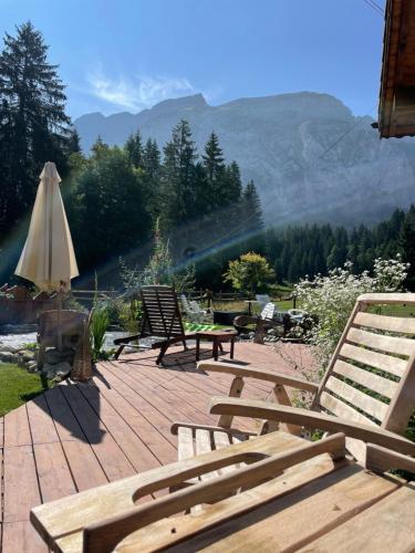 a group of chairs and an umbrella on a patio at Aux lits du bronze Le mole in Mont-Saxonnex