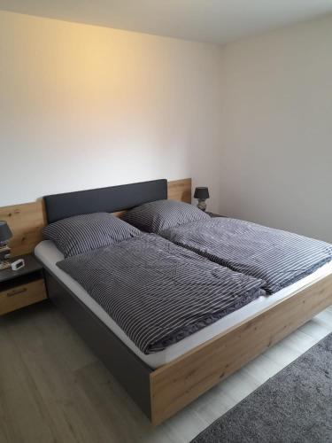 a bed with a wooden frame in a bedroom at Stadtlounge Norden in Norden