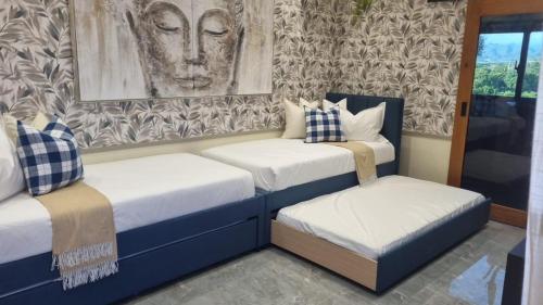 a room with two beds and a painting on the wall at Villa Reyna El placer in Baní