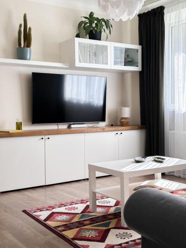 a living room with a flat screen tv on a white cabinet at Sigulda center apartments in Sigulda
