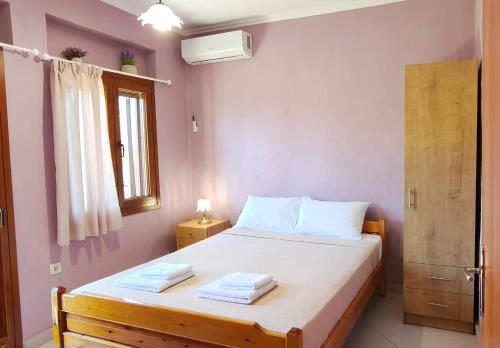 a bedroom with a bed with two towels on it at Theros in Makrygialos