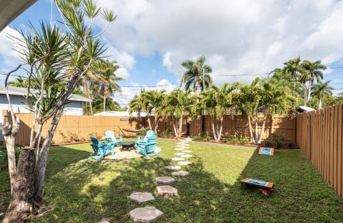 a yard with two blue chairs and a hammock at Tropical Retreat - close to the Beach & to Hard Rock Stadium in Hollywood