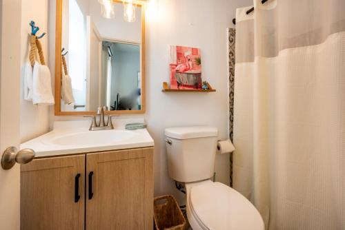 a bathroom with a toilet and a sink and a mirror at Tropical Retreat - close to the Beach & to Hard Rock Stadium in Hollywood