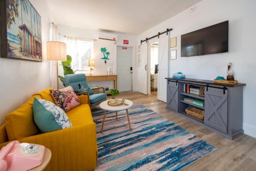 a living room with a yellow couch and a table at Tropical Retreat - close to the Beach & to Hard Rock Stadium in Hollywood