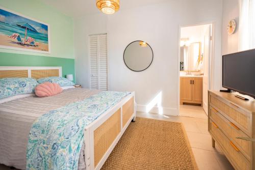 a bedroom with a bed and a flat screen tv at Tropical Retreat - close to the Beach & to Hard Rock Stadium in Hollywood