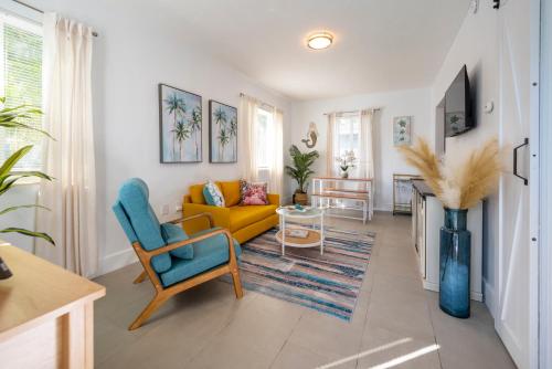 a living room with a yellow couch and a table at Tropical Retreat - close to the Beach & to Hard Rock Stadium in Hollywood
