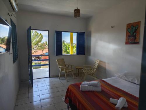 a bedroom with a bed and a table and chairs at Casa Jambo Canoa Quebrada in Canoa Quebrada