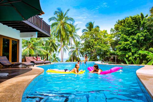 two girls are floating in the swimming pool at a resort at Villa Vadee - Entire Private Villa, 4 Bedrooms, Large Swimming Pool, Ocean View in Thong Nai Pan Noi