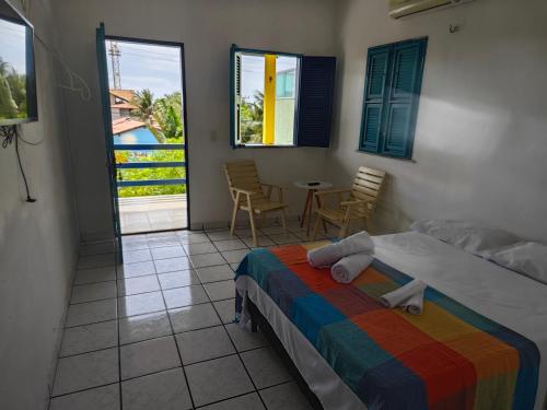 a bedroom with a bed and a table and chairs at Casa Jambo Canoa Quebrada in Canoa Quebrada