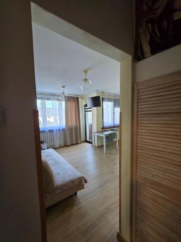 a bedroom with a bed and a table in a room at Apatrament Jagielońska in Legnica