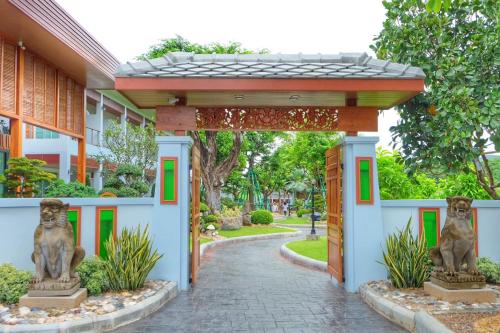 an entrance to a building with two statues of monkeys at Princess River Kwai Hotel in Kanchanaburi