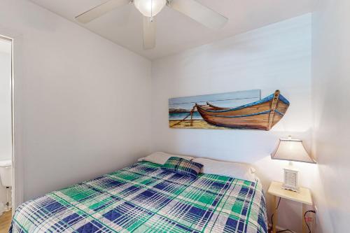 a bedroom with a bed and a painting of a boat at ABOS147 Ocean Sands 136 in Atlantic Beach