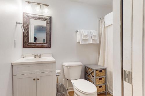 a bathroom with a toilet and a sink and a mirror at ABOS147 Ocean Sands 136 in Atlantic Beach