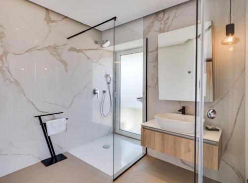a bathroom with a glass shower and a sink at Villa La Bella Vista in Basina