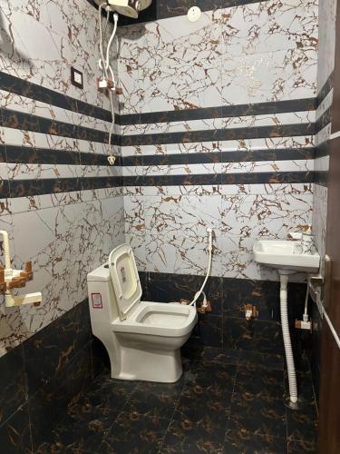 a bathroom with a toilet and a sink at Manavi Home Stay in Mathura