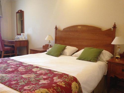 a hotel room with a large bed with green pillows at Troy Hotel in London