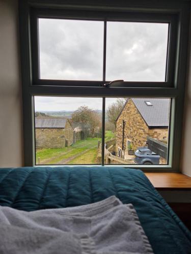 a bedroom window with a view of a church at George and Dragon in Holmesfield