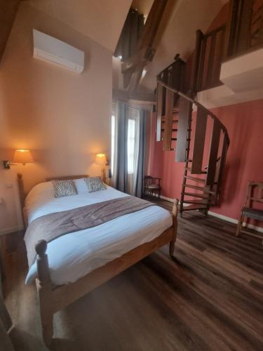 a bedroom with a large bed in a room at Logis Hôtel La Fleur de Lys in Cormatin