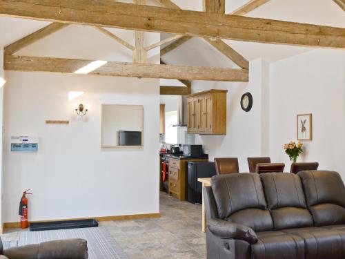 a living room with a couch and a kitchen at The Byre in Great Ayton