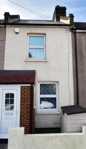 a white house with a door and a window at Stylish Guest House in heart of Dartford Central in Dartford
