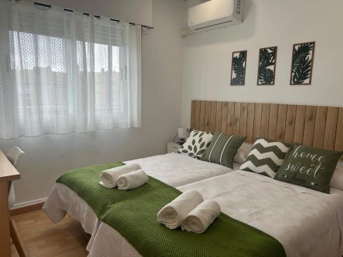 a bedroom with a large bed with towels on it at Entrevías in Albacete