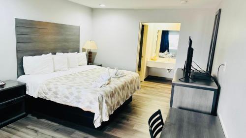 a bedroom with a bed and a flat screen tv at Executive Inn and Suites Houston in Houston