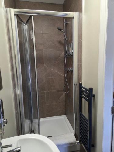 a bathroom with a shower with a toilet and a sink at George and Dragon in Holmesfield