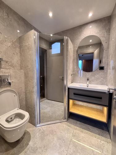 a bathroom with a shower and a toilet and a sink at Denizati Holiday Village in Gumuldur