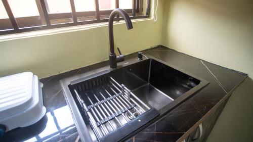 a kitchen sink with a faucet next to a window at cozyairbnb in Otinshi