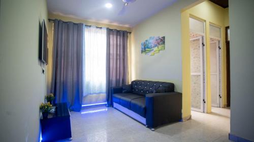 a living room with a blue couch and a window at cozyairbnb in Otinshi