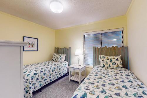 a bedroom with two beds and a window at ABPAB167 Blue Haven Beach Retreat in Atlantic Beach