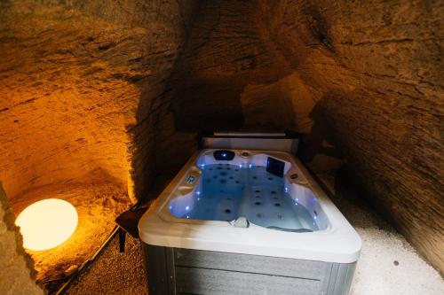 a bath tub in a cave with a stone wall at Le Cocon in Doué-la-Fontaine