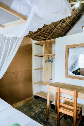 a room with a table and a mirror and a window at Kanga Beach Paradise in Mafia Island