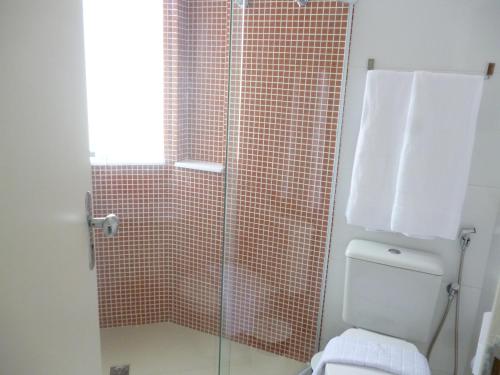 a bathroom with a glass shower with a toilet at Flat no Farol in Salvador